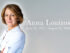 Alt Text: ``` Scenic designer Anna Louizos in a white shirt, with her name and the dates June 24, 1957 – August 25, 2026