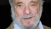 Stephen Sondheim, white-bearded and smiling, in a tweed jacket over a blue open-collar shirt